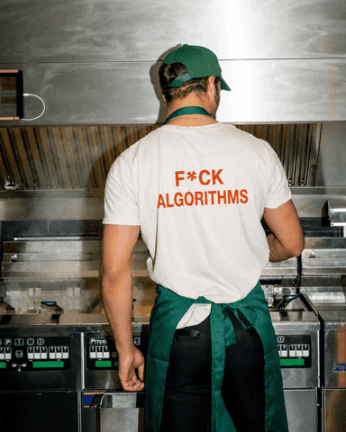 Person working in a kitchen wearing an anti-algorithm shirt