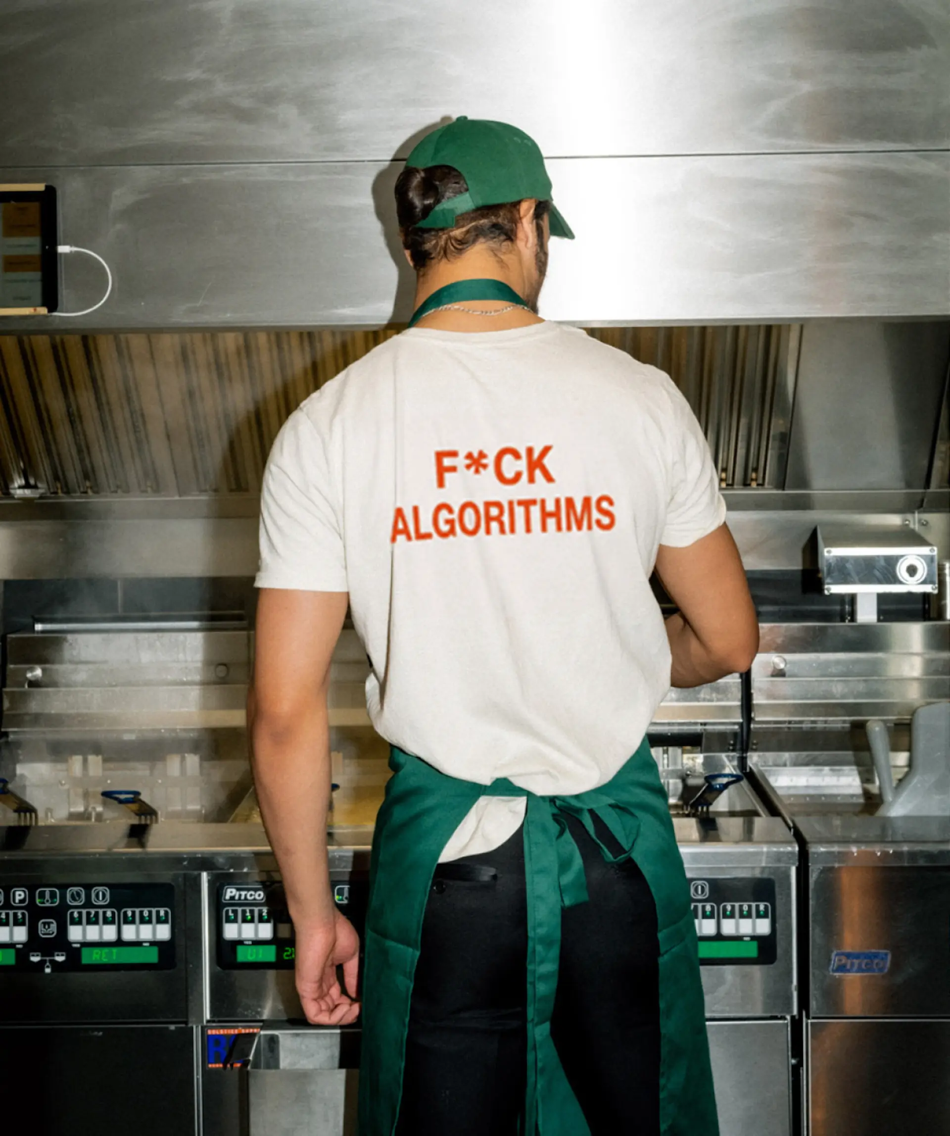 Person working in a kitchen wearing an anti-algorithm shirt